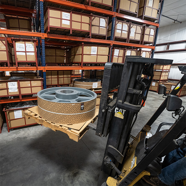 Forklift moving large sheave in the MasterDrive warehouse